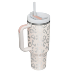 A handled tumbler with a light pink and gray leopard print pattern, featuring a white lid with a clear straw on a white background.