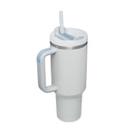 40oz water tumbler with handle sitting on a gym bench next to workout gear.