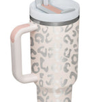 Insulated 40oz tumbler with straw placed on a modern office desk setup.